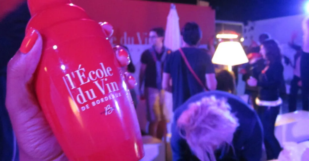 Bottle of wine with a Bordeaux vineyard backdrop at Bordeaux Wine Festival.
